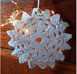 A white snowflake with lights on a string

Description automatically generated