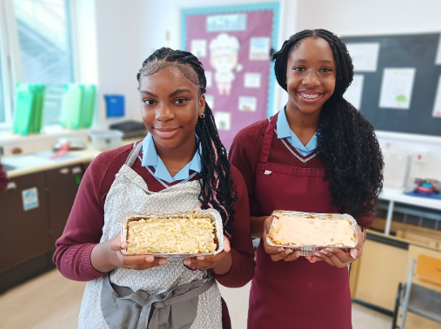 Two women holding food in foil containers

AI-generated content may be incorrect.